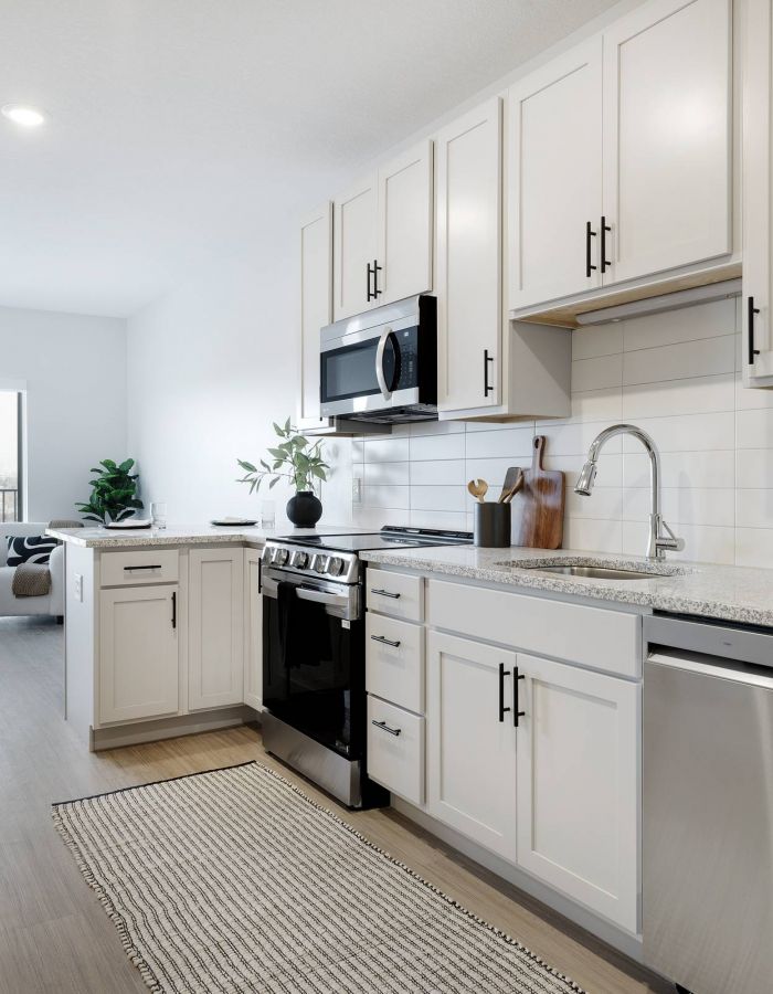 Modern kitchen with white cabinets, stainless steel appliances, and granite countertops.